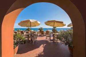 un arco con mesas, sillas y sombrillas en Miramare di Varigotti en Varigotti