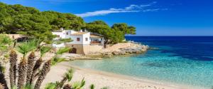 a house on a beach next to the ocean at C´AN PICAFORT NEAR THE SEA in Can Picafort