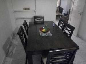 Apartment in Dar Homestay في دار السلام: طاولة غرفة الطعام مع وعاء من الفواكه عليها