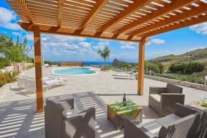 a patio with a pool and a wooden pergola at Villa Ninetta in Scopello