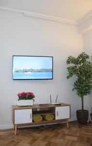 - un salon avec une télévision sur un mur blanc dans l'établissement Apartamento com Patio, à Aveiro