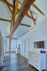 a bedroom with white walls and wooden beams at La Maison Blanche in Beaune