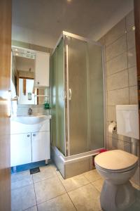 uma casa de banho com um chuveiro, um WC e um lavatório. em Apartment Boras Lux em Cavtat