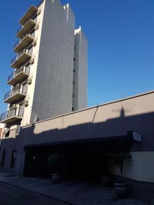 un edificio alto con un garage di fronte di Dallas Hotel -Motel- a Buenos Aires