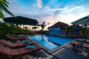 a swimming pool with lounge chairs and umbrellas at Sedok Jineng Villa in Nusa Lembongan