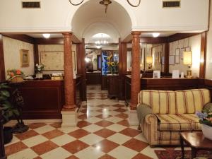 a lobby with columns and a couch and a counter at Hotel Falier in Venice