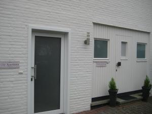 a white building with a door and two windows at City-Apartment Rietberg in Rietberg