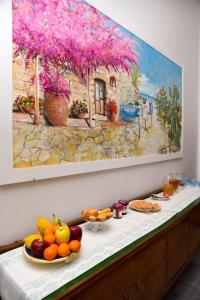a table with fruit on it with a painting on the wall at DolceLina Home in Lampedusa