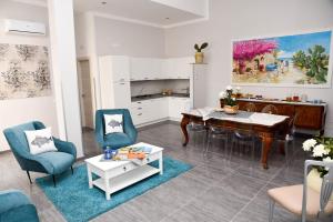a living room with a table and chairs and a kitchen at DolceLina Home in Lampedusa