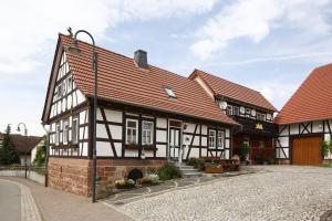 een zwart-wit gebouw met rood dak bij Landhotel Zur Grünen Kutte in Bernshausen