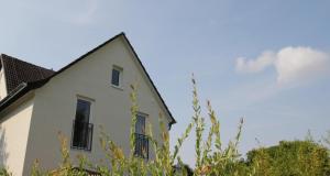 a white house with black windows and trees at Apartment Maria Detmold in Detmold