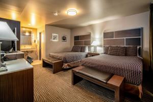 a hotel room with two beds and a desk at Crescent Bay Inn in Laguna Beach