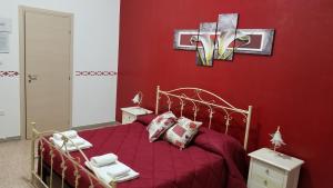グロッターリエにあるB&B da Minoの赤い壁のベッド付きの赤いベッドルーム