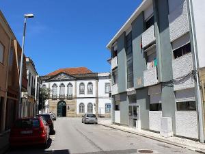 une rue avec des voitures garées devant un bâtiment dans l'établissement Apartamento com Patio, à Aveiro
