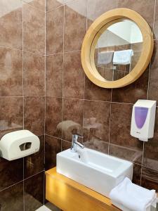 a bathroom with a sink and a mirror at WW Hostel & Suites in Coimbra