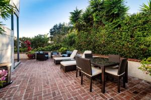 a patio with chairs and tables on a brick patio at Crescent Bay Inn in Laguna Beach