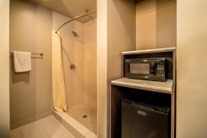 a bathroom with a shower and a microwave at Crescent Bay Inn in Laguna Beach