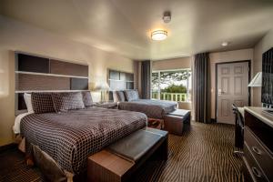 a hotel room with a bedroom with a bed and a couch at Crescent Bay Inn in Laguna Beach