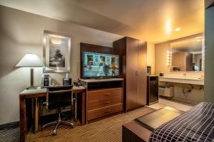 a hotel room with a bed and a desk with a television at Crescent Bay Inn in Laguna Beach