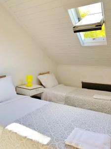 two beds in a room with a window and a window at WW Hostel & Suites in Coimbra
