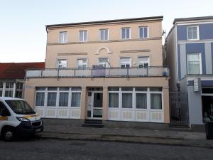 Ferienwohnung preiswert und strandnah في فارنمونده: شاحنة بيضاء متوقفة أمام مبنى