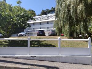 uma cerca branca em frente a um edifício em Hotel Astoria em Saint-Étienne