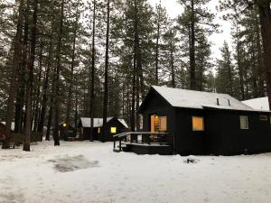 a black cabin in the woods in the snow at Colorado Lodge in Big Bear Lake