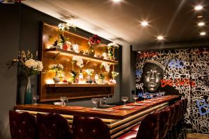 a restaurant with a table with chairs and a painting of a rapper at Hotel 32 32 in New York