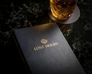 a lost hours book on a table with a glass of whiskey at Hotel 32 32 in New York