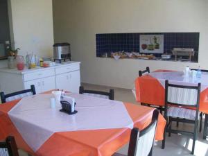 uma cozinha com duas mesas com laranja e branco em Pousada Costa Coral em Tamandaré