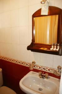 a bathroom with a sink and a mirror at Hotel Rio Piedra in Cuenca