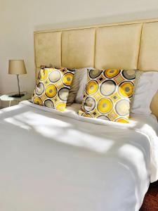 a bed with white sheets and pillows on it at WW Hostel & Suites in Coimbra