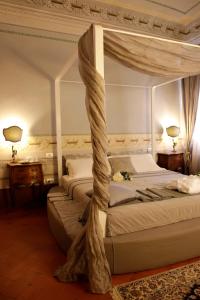 a bedroom with two beds and a canopy bed at Residenza D'Epoca -Santa Caterina in Pisa