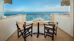 a table and two chairs on a balcony with the ocean at Ilia Mare in Ilia
