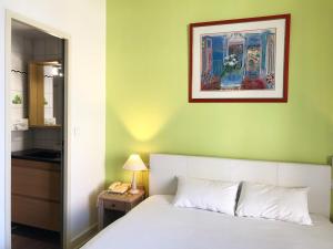 - une chambre avec un lit et une photo sur le mur dans l'établissement Brit Hotel Aux Sacres Reims Centre, à Reims