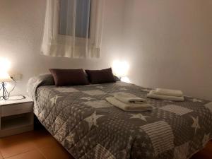 a bedroom with a bed with two towels on it at Apartaments S'Arenella in Cadaqués