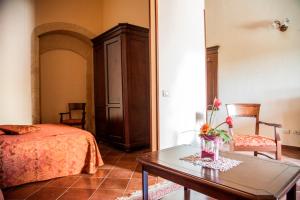 a bedroom with a bed and a table with flowers on it at Feudo Bauly in Palazzolo Acreide