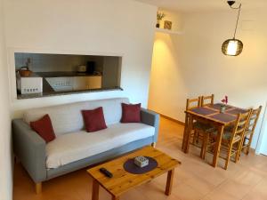 a living room with a couch and a table at Apartaments S'Arenella in Cadaqués