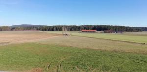 un campo vacío con una granja en la distancia en 34a Paulstraße en Postbauer-Heng