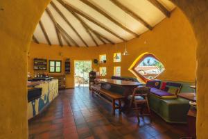 a kitchen with orange walls and a table and chairs at YVY CASA HOTEL in Samaipata