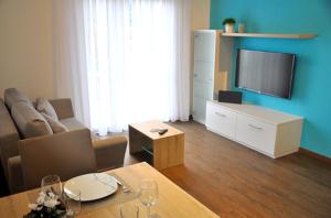 Una sala de estar con una mesa y un televisor. en rent-my-apartment, en Rietheim-Weilheim