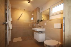 bagno con servizi igienici, lavandino e specchio di rent-my-apartment a Rietheim-Weilheim