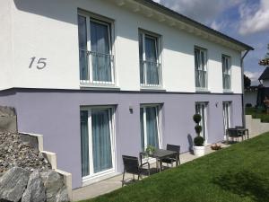 une maison blanche avec des chaises devant elle dans l'établissement rent-my-apartment, à Rietheim-Weilheim