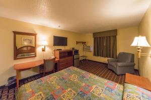 a hotel room with a bedroom with a bed and a desk at Patuxent Inn in La Plata