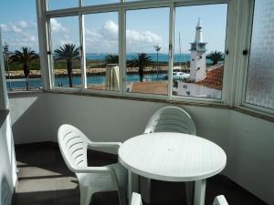 ラゴスにあるCasa AUGUSTAの白いテーブルと椅子、窓(灯台付)