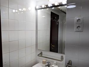 a white tiled bathroom with a sink and a mirror at Casa em Alfama in Lisbon +17 photos