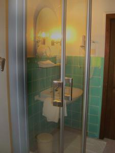 Hotel-Restaurant Burg-Ramstein في Kordel: حمام ذو بلاط أخضر مع دش ومغسلة