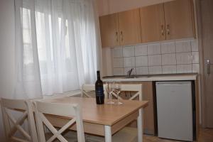 a kitchen with a table with a bottle of wine on it at Marinis Boutique Rooms in Iraklitsa