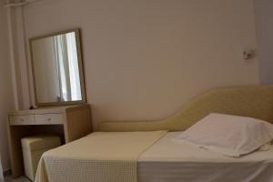 a small bedroom with a bed and a mirror at Marinis Boutique Rooms in Iraklitsa