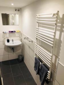 een witte badkamer met een wastafel en een spiegel bij Hotel Krone in Ostfildern